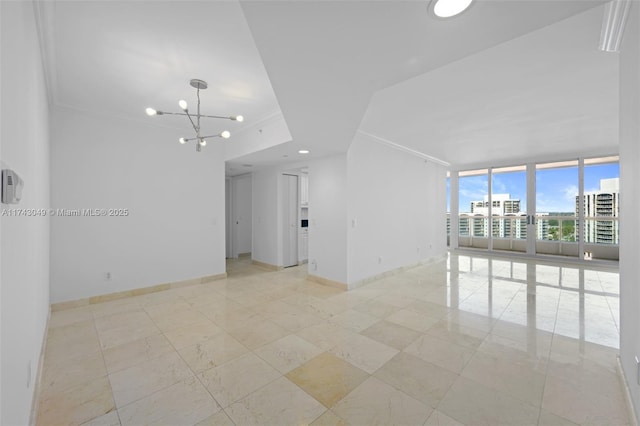 empty room featuring an inviting chandelier, crown molding, and expansive windows