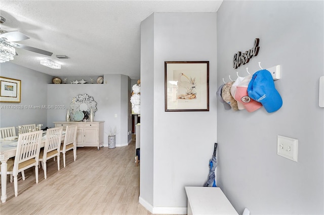 corridor featuring light hardwood / wood-style flooring and a textured ceiling