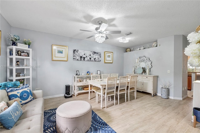 dining room featuring ceiling fan, light hardwood / wood-style floors, and a textured ceiling