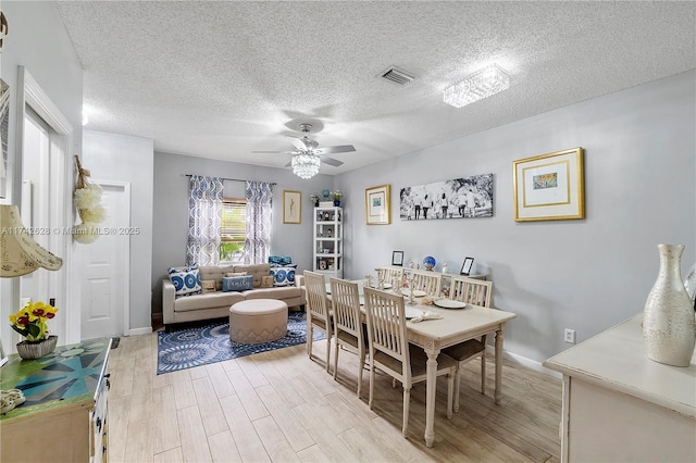 dining space featuring ceiling fan, light hardwood / wood-style floors, and a textured ceiling