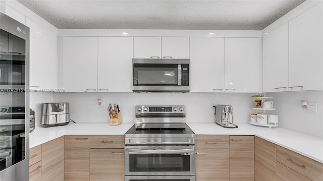 kitchen featuring white cabinetry, appliances with stainless steel finishes, and a textured ceiling