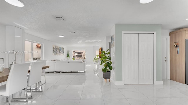 hall featuring a textured ceiling