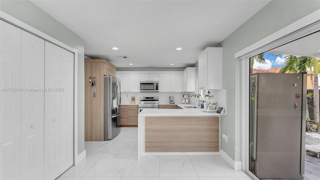 kitchen featuring stainless steel appliances, white cabinetry, and sink