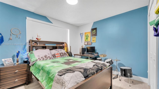 bedroom with light hardwood / wood-style flooring and a textured ceiling