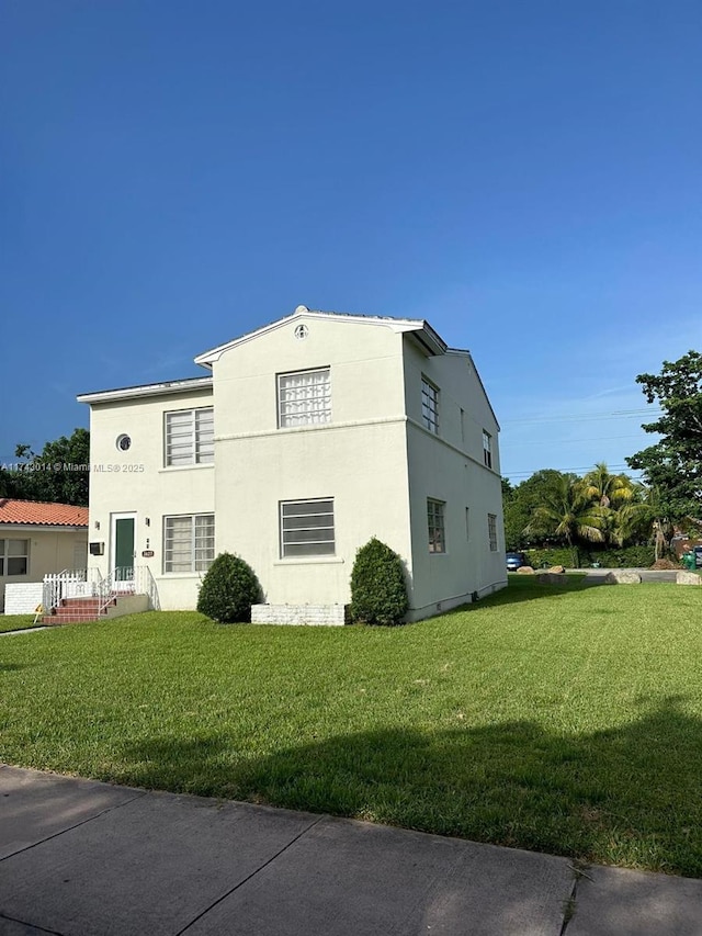 view of side of home with a yard