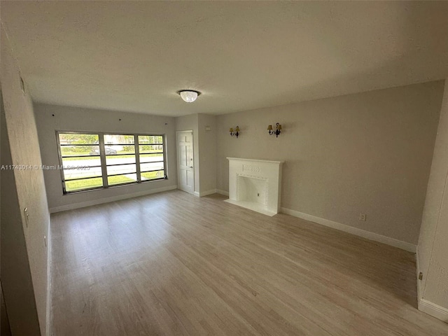 unfurnished room with a textured ceiling and light hardwood / wood-style floors