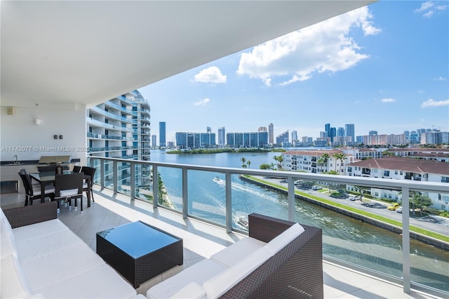 balcony with an outdoor living space, a water view, and sink