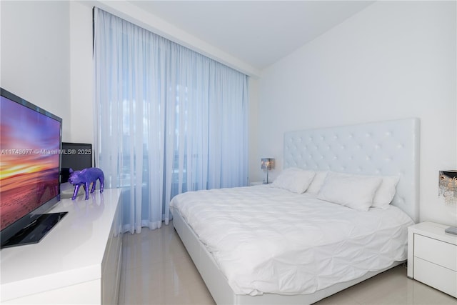 bedroom featuring light tile patterned flooring and vaulted ceiling