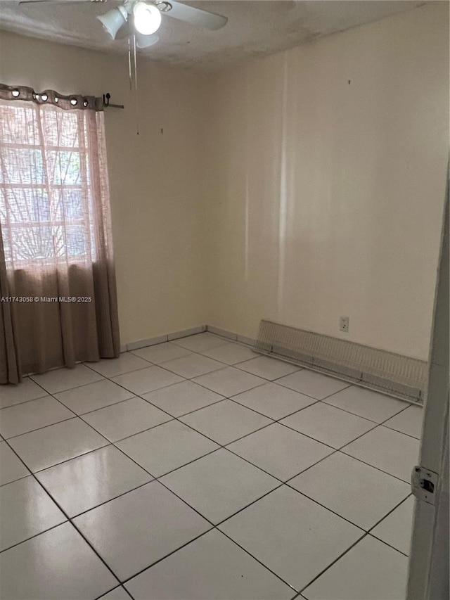 tiled spare room featuring ceiling fan