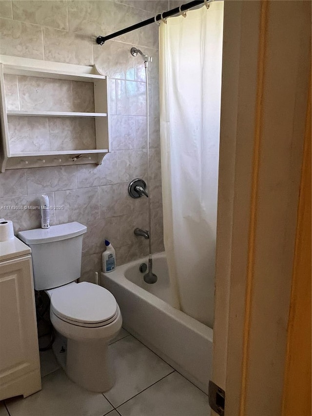 bathroom featuring shower / tub combo with curtain, toilet, tile patterned flooring, and tile walls