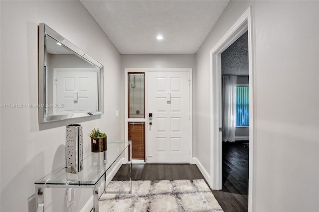 foyer entrance featuring dark hardwood / wood-style floors and a textured ceiling