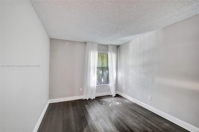 empty room with dark hardwood / wood-style floors and a textured ceiling