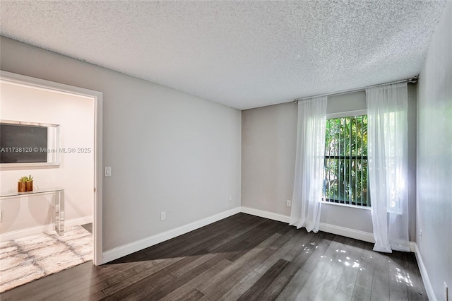 spare room with dark hardwood / wood-style floors and a textured ceiling