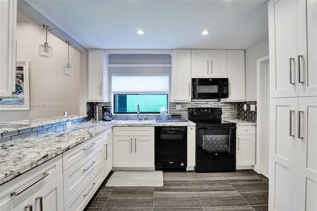 kitchen featuring hanging light fixtures, white cabinetry, backsplash, and black appliances