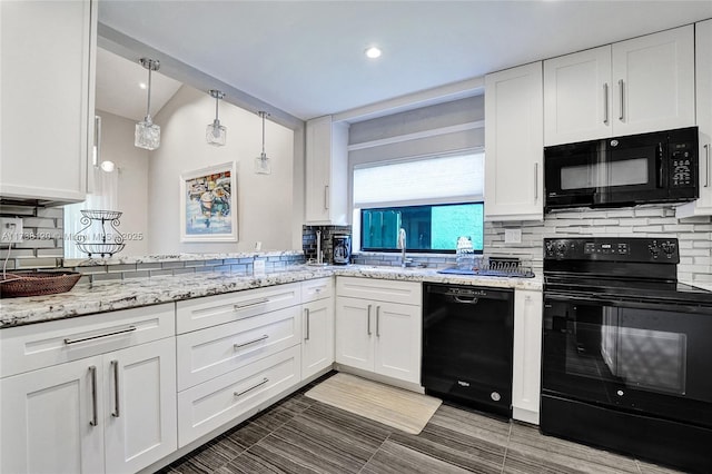 kitchen featuring sink, black appliances, backsplash, pendant lighting, and white cabinets