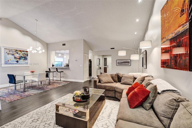 living room with a notable chandelier, hardwood / wood-style flooring, high vaulted ceiling, and a textured ceiling