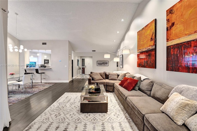 living room featuring hardwood / wood-style flooring, lofted ceiling, and a textured ceiling