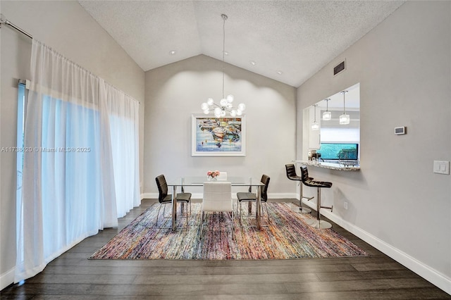 dining space with lofted ceiling, an inviting chandelier, a textured ceiling, and dark hardwood / wood-style flooring