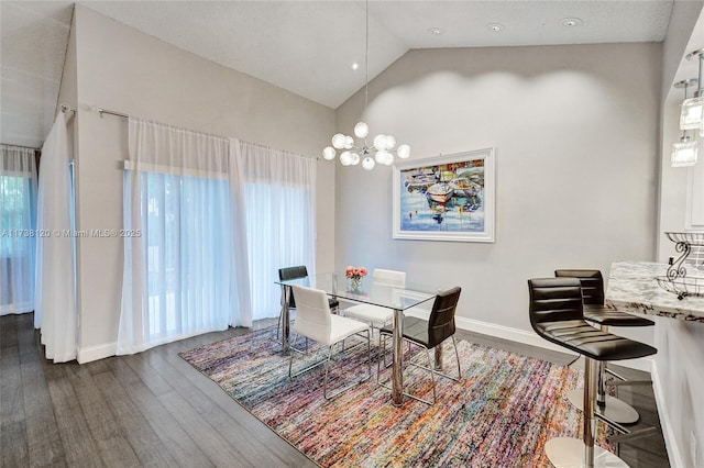 dining room featuring vaulted ceiling, dark wood-type flooring, and an inviting chandelier