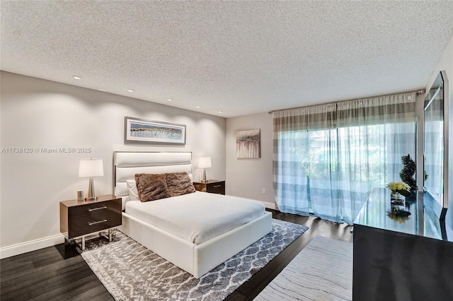 bedroom featuring dark hardwood / wood-style flooring and a textured ceiling