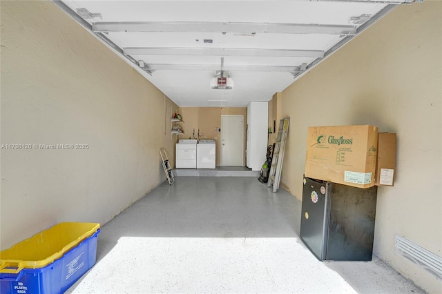 garage with a garage door opener and washing machine and dryer