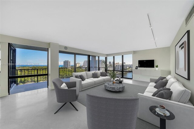 living room featuring rail lighting and concrete flooring