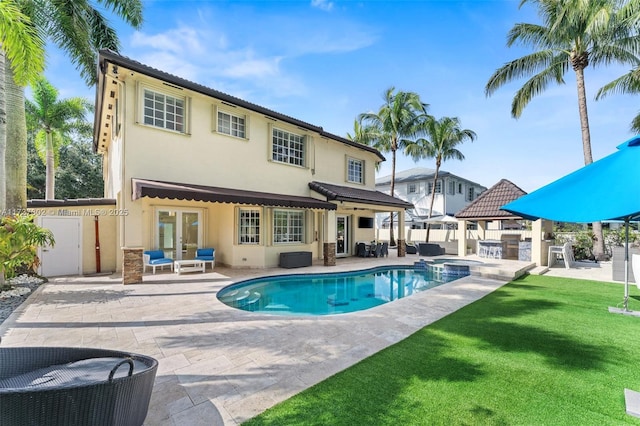 rear view of property with a gazebo, a pool with hot tub, and a patio area