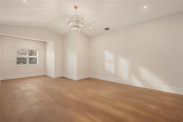 unfurnished room with wood-type flooring, lofted ceiling, and a notable chandelier