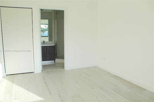 unfurnished room featuring sink and light hardwood / wood-style flooring