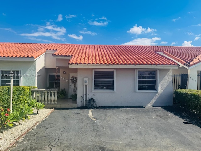 view of front facade featuring a tiled roof and stucco siding