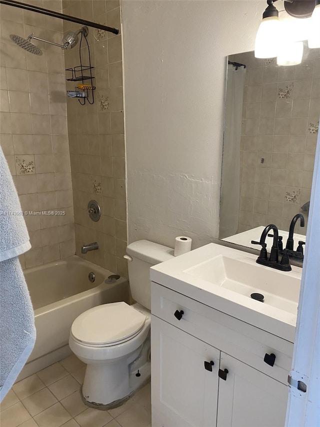 full bathroom featuring vanity, tiled shower / bath combo, tile patterned floors, and toilet