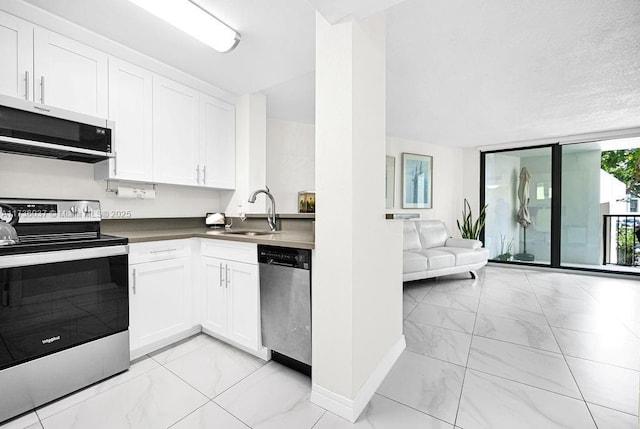 kitchen featuring appliances with stainless steel finishes, sink, and white cabinets