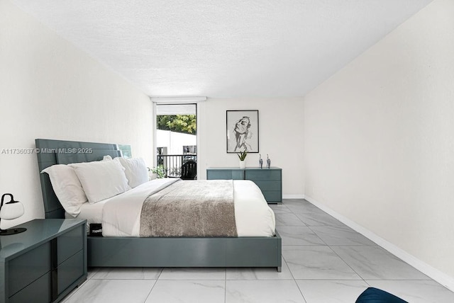 bedroom featuring access to exterior and a textured ceiling