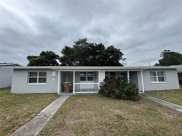 ranch-style house featuring covered porch and a front lawn