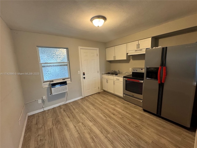 kitchen with sink, appliances with stainless steel finishes, a wall unit AC, light hardwood / wood-style floors, and white cabinets