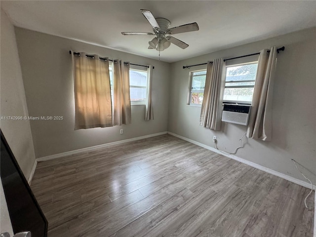 spare room featuring cooling unit, light hardwood / wood-style flooring, and ceiling fan