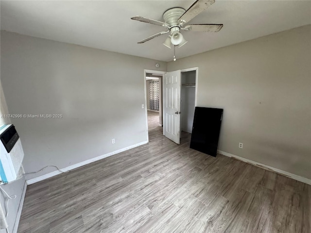 unfurnished bedroom with ceiling fan, heating unit, light hardwood / wood-style floors, and a closet