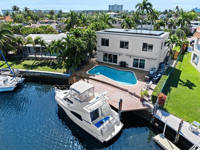 view of swimming pool featuring a patio, a boat dock, and a water view