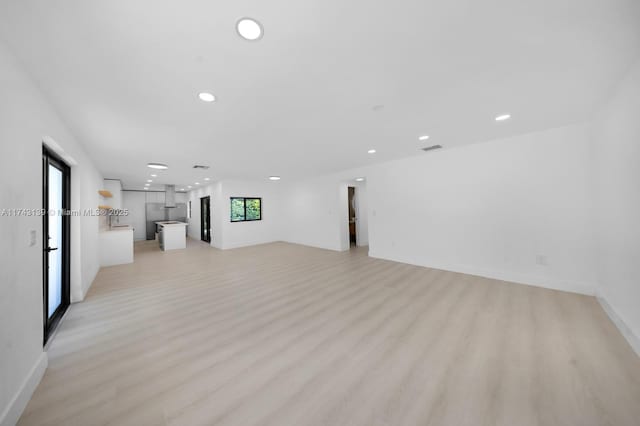 unfurnished living room with recessed lighting, visible vents, light wood-style flooring, and baseboards