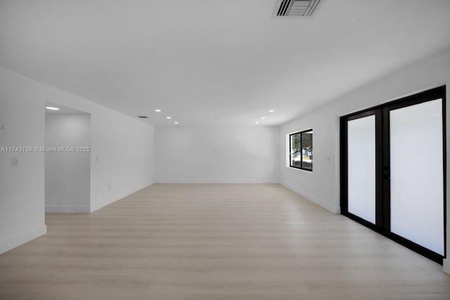 spare room with light wood-style floors, recessed lighting, visible vents, and baseboards