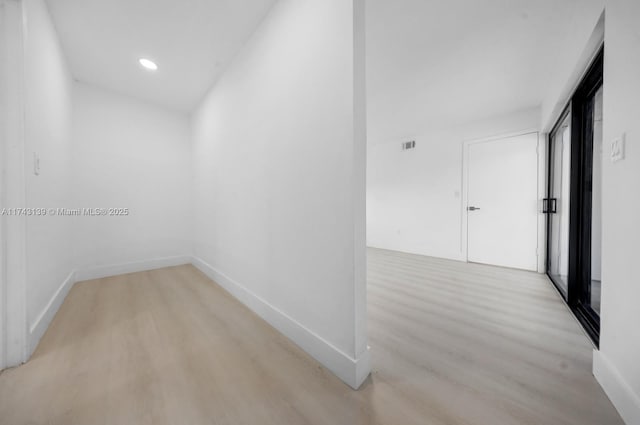 hall with light wood-type flooring, visible vents, baseboards, and recessed lighting