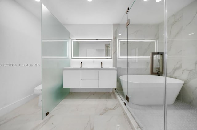 full bathroom featuring marble finish floor, a soaking tub, and a sink