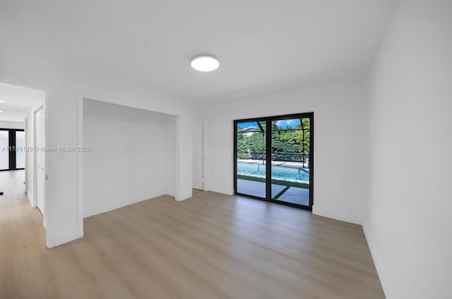 empty room with light wood-style floors and baseboards