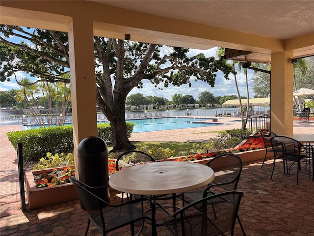 view of patio / terrace featuring a water view and a community pool