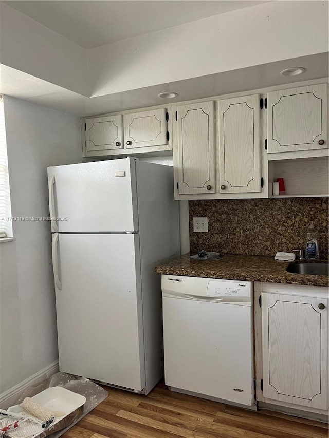 kitchen with hardwood / wood-style floors, tasteful backsplash, sink, white cabinets, and white appliances