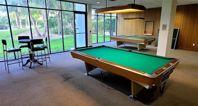 recreation room with floor to ceiling windows, carpet, a drop ceiling, pool table, and wood walls