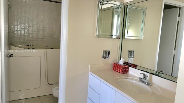 bathroom featuring vanity, toilet, washer / dryer, and tile patterned flooring