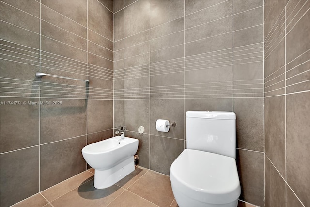 bathroom featuring a bidet, tile walls, tile patterned floors, and toilet