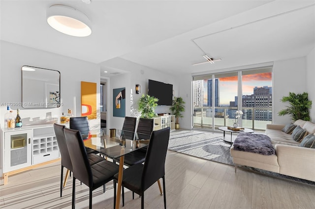 dining space with floor to ceiling windows and light wood-type flooring