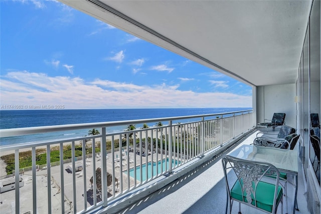 balcony featuring a view of the beach and a water view